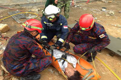 <p>SCDF rescuer working together with counterparts from Brunei  during the simulated exercise</p>