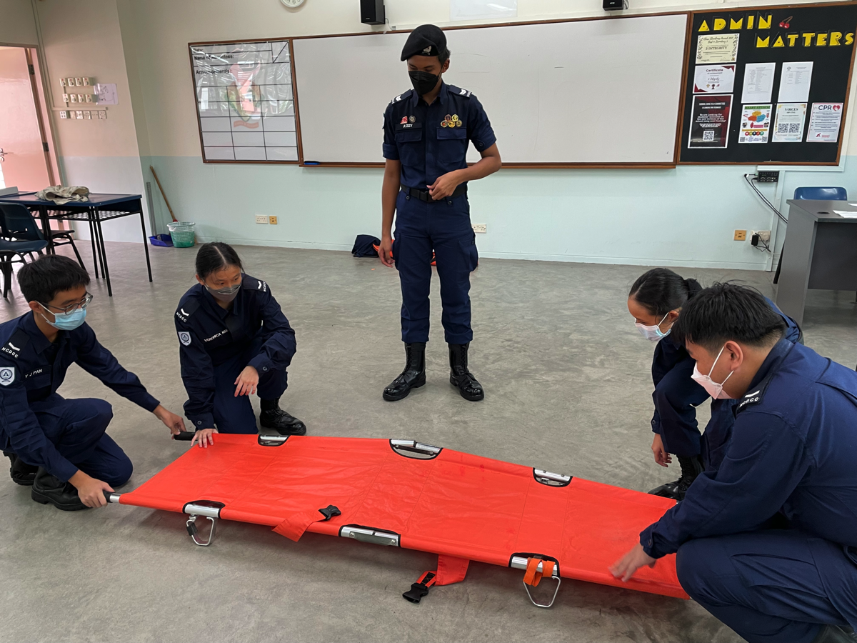 CPL (NCDCC) A’zizy guiding his junior NCDCC mates on using a stretcher