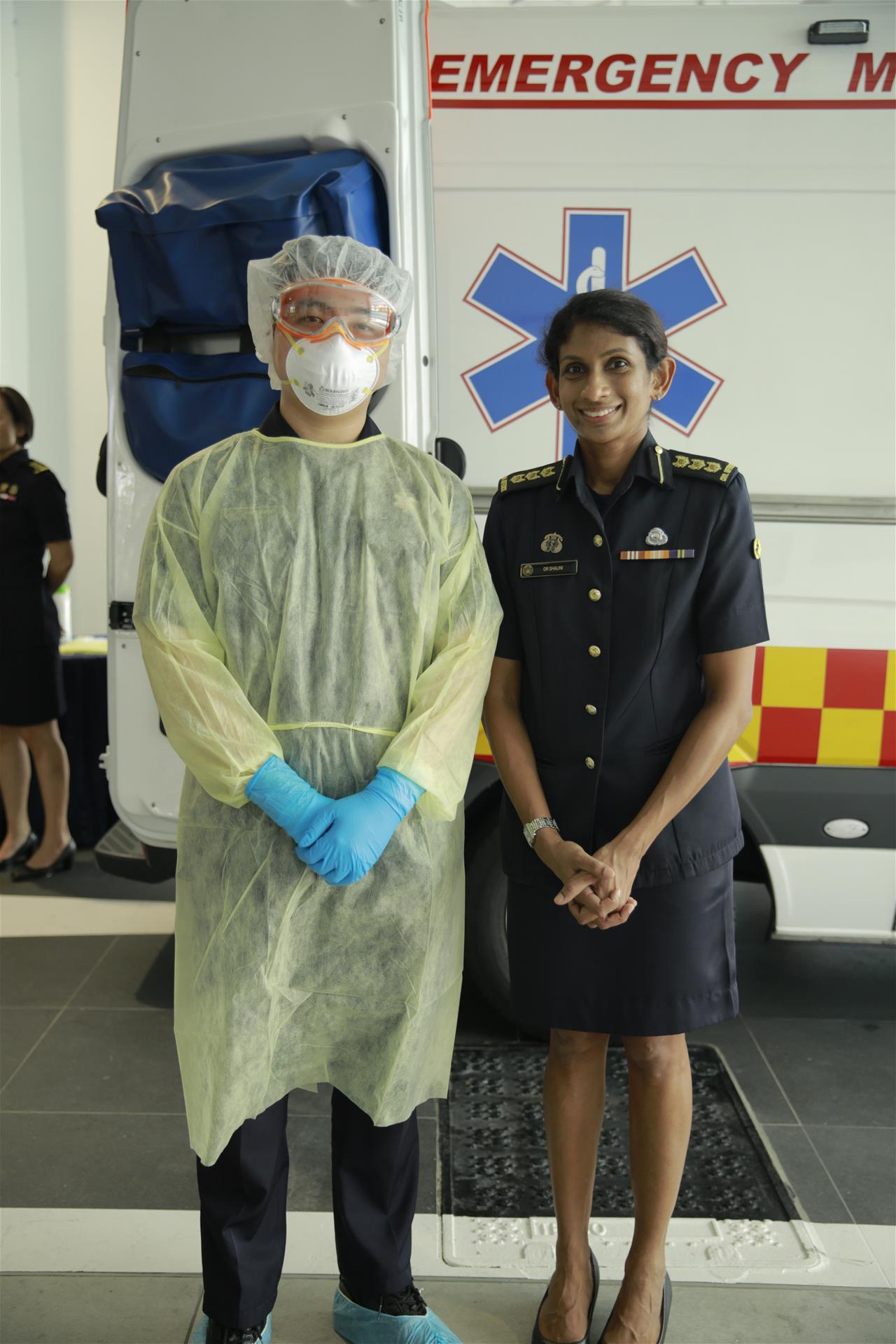A frontline Emergency Medical Services (EMS) personnel (left) in full  Personal Protective Equipment (PPE) with SCDF’s Chief Medical Officer, COL (Dr) Shalini Arulanandam (right).