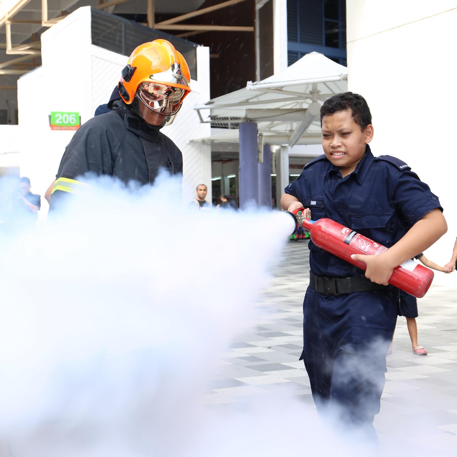 Khidir learning how to use a fire extinguisher