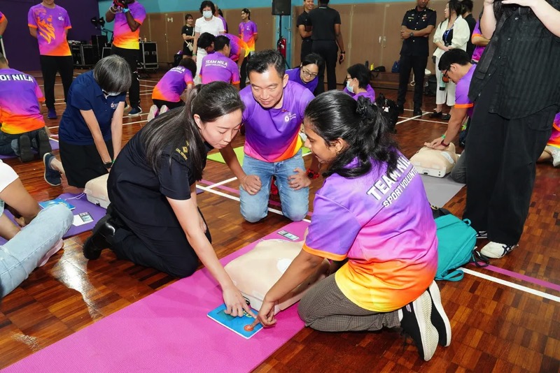 Senior Parliamentary Secretary for Culture, Community and Youth of Singapore, Mr Eric Chua (middle) looking on as LTA Jasmine guides a Team Nila volunteer in CPR-AED skills. PHOTO - Team Nila